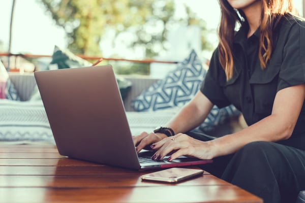 mujer tecleando y mirando el computador